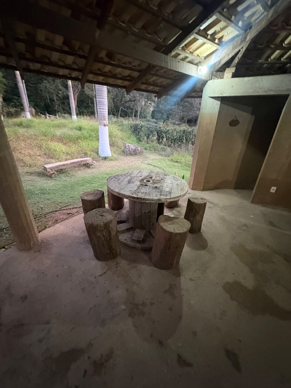 Mesa de carretel com banquinhos sob a área coberta