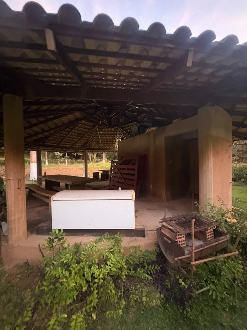 Área coberta do sítio com mesa e churrasqueira